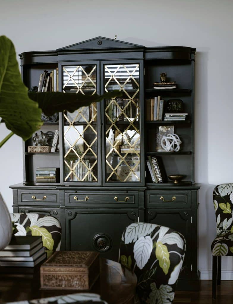 Elegant black display cabinet with gold detailing and decorative bookshelves. Add luxury to your living space.
