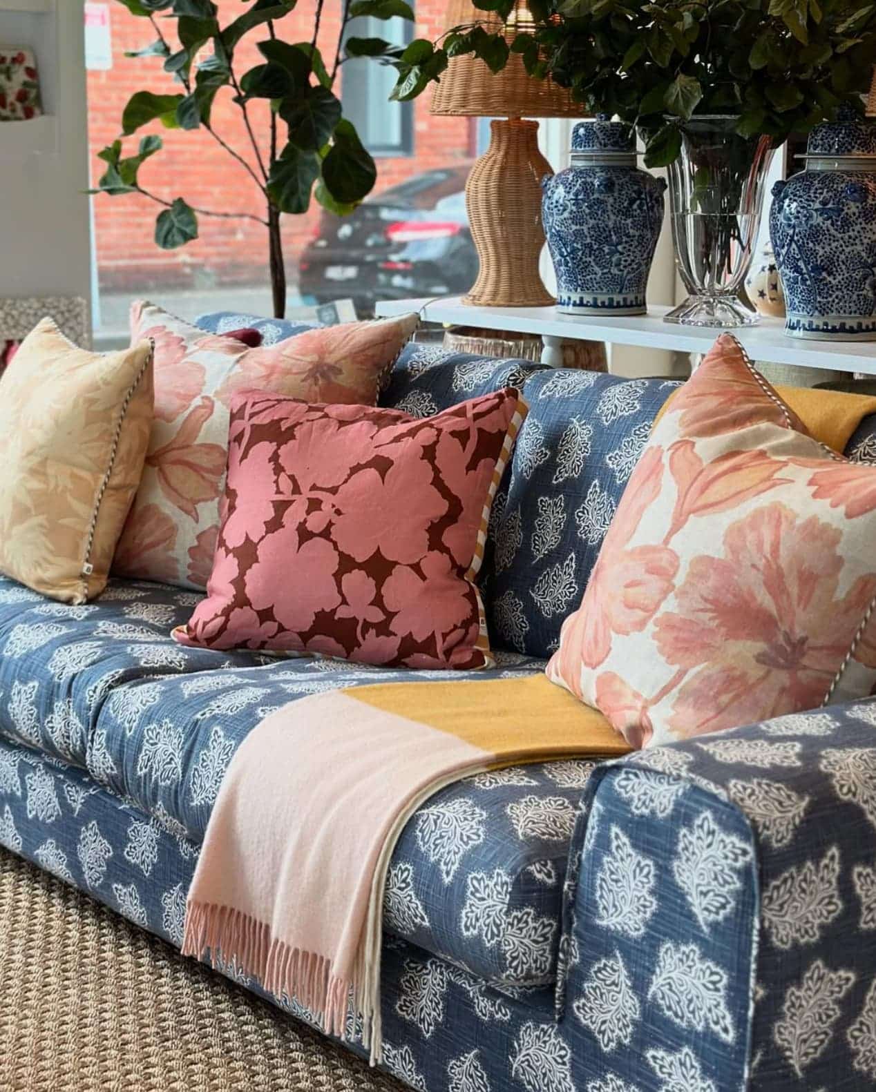 Blue patterned sofa with floral cushions styled by JACKA DESIGN