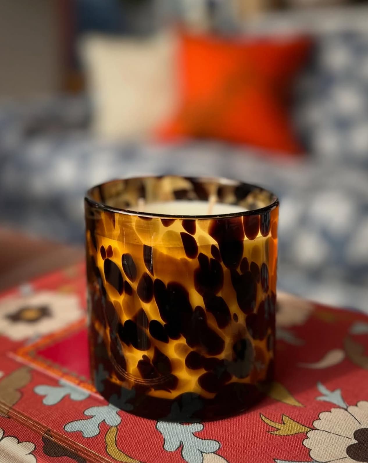 Decorative tortoiseshell candle on floral table styled by JACKA DESIGN