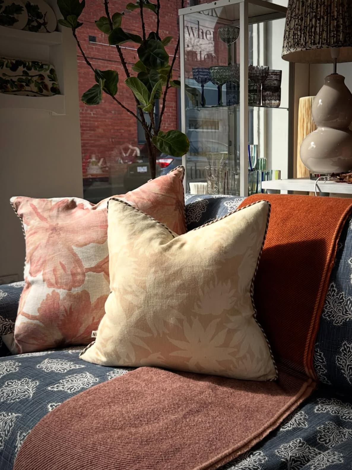 Close-up of floral cushions with throw on patterned sofa styled by JACKA DESIGN