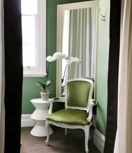 Tall mirror creating the illusion of space in green room